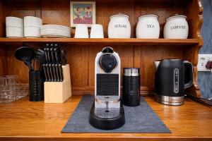 a coffeemaker sitting on top of a wooden table at 12a Infinity Guesthouse in Pietermaritzburg