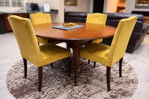 a wooden table with yellow chairs on a rug at 12a Infinity Guesthouse in Pietermaritzburg