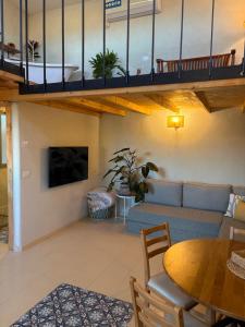 a living room with a loft with a couch and a table at מים במדבר in Zuqim