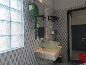 a bathroom with a bowl sink and a mirror at Nyoman Guest House in Singaraja