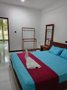 a bedroom with a bed with a towel on it at Bellamoon Resort in Trincomalee