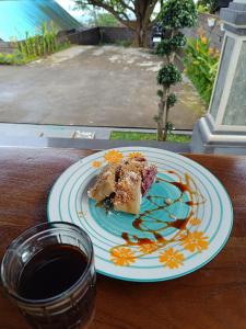 a plate of food on a table with a cup of coffee at Nyoman Guest House in Singaraja