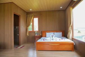 a bedroom with a bed with a dog on it at Bàu Trắng Garden in Ấp Nhơn Hòa