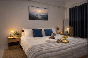a teddy bear sitting on a bed in a bedroom at Cozy house hatyai in Sathani Khlong Rian