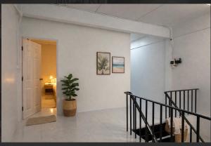 a hallway with a staircase and a potted plant at Cozy house hatyai in Sathani Khlong Rian
