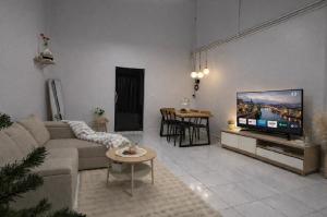 a living room with a couch and a flat screen tv at Cozy house hatyai in Sathani Khlong Rian