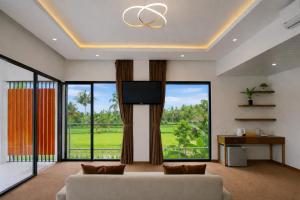 a living room with a couch and a flat screen tv at Nirvana Hotel Resort Tetebatu in Tetebatu