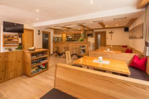 a living room with wooden tables and a kitchen at Garni Irsara in San Cassiano