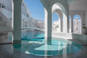 a swimming pool in a building with a bridge at Kanale's Rooms & Suites in Naousa