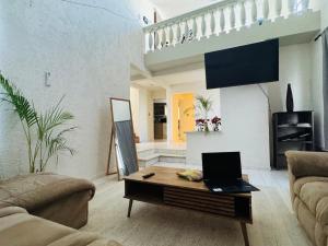 a living room with a laptop on a coffee table at Casa Baja, with Gym & Terraces in La Paz