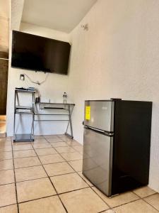 a kitchen with a refrigerator and a tv on the wall at Casa Baja, with Gym & Terraces in La Paz