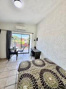 a bedroom with a bed and a desk and a window at Casa Baja, with Gym & Terraces in La Paz