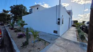 a white building on a sidewalk next to a street at Casa Baja, with Gym & Terraces in La Paz