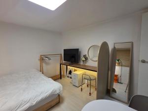 a bedroom with a bed and a desk with a television at dalcom kunkuk in Seoul