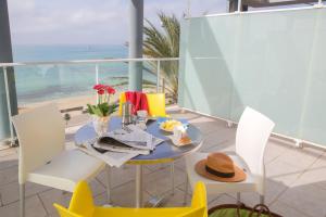 un comedor con mesa y sillas y el océano en Apartamentos Mix Bahia Real en El Arenal