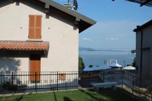 a white house with a balcony with a view of the water at Paradiso sul Lago Maggiore in Baveno
