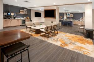 a living room with a table and chairs and a kitchen at Oshkosh Marriott Waterfront Hotel & Convention Center in Oshkosh