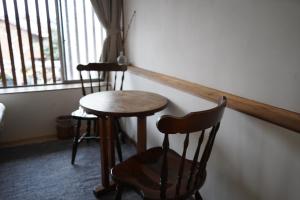 a table and two chairs in a room with a window at Masukichi -hostel,cafe,souvenir,guide- in Seto