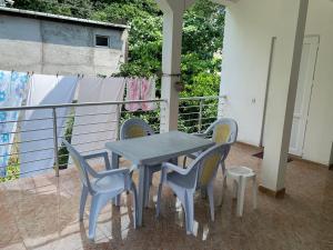 a table and four chairs on a porch with a table and chairs at Marina kvariati in Kvariati