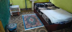 a bedroom with two beds and a rug on the floor at Christa Homestay in Mangalore