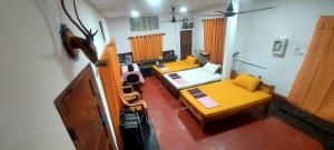 a room with two beds and a guitar in it at Bird Nest Homestay in Jaffna
