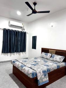 a bedroom with a bed and a ceiling fan at Sai Lodge in Ale