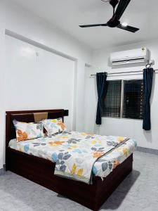 a bedroom with a bed and a ceiling fan at Sai Lodge in Ale