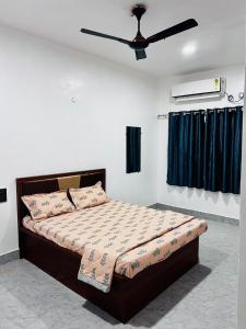 a bedroom with a bed with a ceiling fan at Sai Lodge in Ale