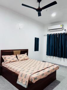 a bedroom with a bed with a ceiling fan at Sai Lodge in Ale