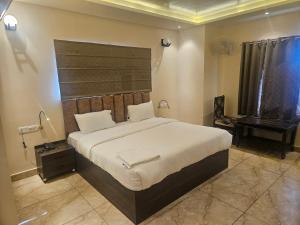 a bedroom with a large bed and a table at Shahenshah Hotel in Civil Lines, Prayagraj in Prayagraj +22 photos