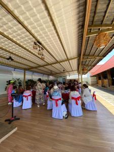 a group of people in dresses are sitting in a room at Bàu Trắng Garden in Ấp Nhơn Hòa