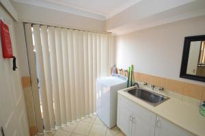 a small kitchen with a sink and a refrigerator at Blue Ocean Villa 7 - Kalbarri, WA in Kalbarri