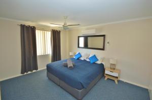 a bedroom with a blue bed and a mirror at Blue Ocean Villa 7 - Kalbarri, WA in Kalbarri +6 photos