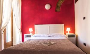 a bedroom with a bed with a red wall at Veronetta House in Verona