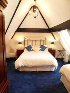 een slaapkamer met een groot wit bed en een blauw tapijt bij Ascot House in York