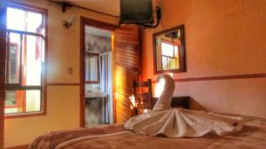 a dress on a bed in a room with windows at Hotel Real del Valle in San Cristóbal de Las Casas