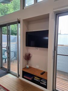 a living room with a flat screen tv on a wall at Studio Apartment close to the CBD in Unley