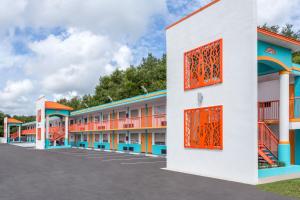 a row of buildings with orange and blue accents at Howard Johnson by Wyndham Ocala FL I-75 in Ocala