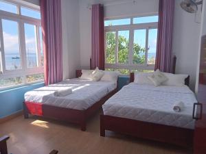 two beds in a room with two windows at Thanh Tran Guesthouse Lý Sơn in Ly Son +32 photos