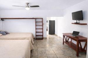 a bedroom with two beds and a table and a tv at Suite moderna para 2, a 5 min del Centro in Ciudad Victoria