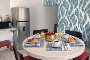 a table with plates of fruit on it in a kitchen at Suite moderna para 2, a 5 min del Centro in Ciudad Victoria