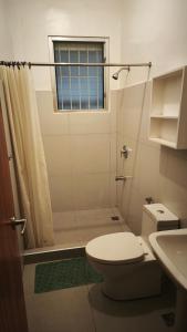 a bathroom with a toilet and a shower with a window at Pension Natividad in Manila +44 photos
