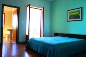 ein blaues Schlafzimmer mit einem Bett mit einer blauen Decke in der Unterkunft Appartamento Torre in Ioppolo
