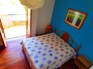 ein Schlafzimmer mit einem Bett und einer blauen Wand in der Unterkunft Appartamento Torre in Ioppolo