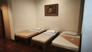 a room with three beds and a picture on the wall at Pension Natividad in Manila