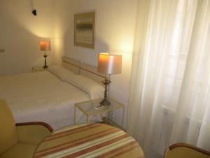um quarto com uma cama e uma mesa com um candeeiro em Atocha Palace em Madrid