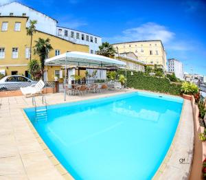 a large blue swimming pool next to a building at Hotel Pousada da Mangueira in Salvador