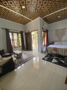 a bedroom with a bed and a couch in a room at Batukaras beach hill villas in Batukaras