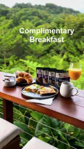 a table with breakfast food and a glass of orange juice at Waterfall Lodge in Carool
