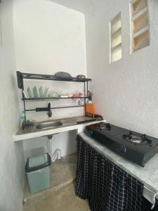 a kitchen with a sink and a stove at Batukaras beach hill villas in Batukaras